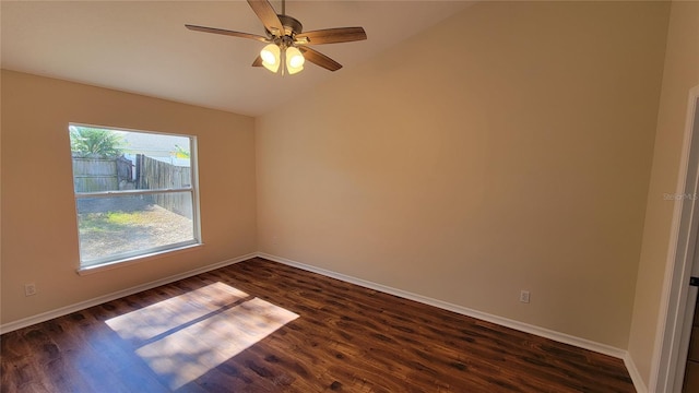 spare room with dark hardwood / wood-style floors, ceiling fan, and vaulted ceiling