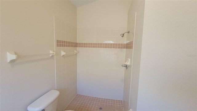 bathroom featuring tiled shower, tile patterned floors, and toilet