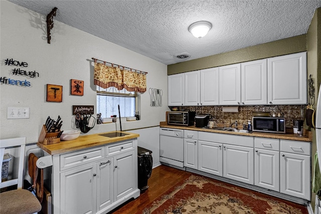 kitchen with white cabinets, dishwasher, dark wood-type flooring, and a textured ceiling