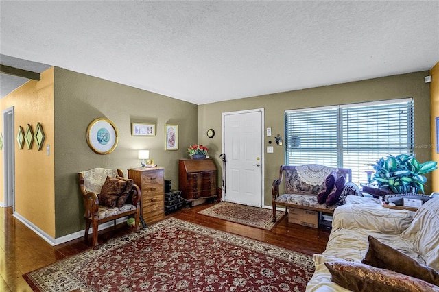 living room featuring a textured ceiling and dark hardwood / wood-style floors