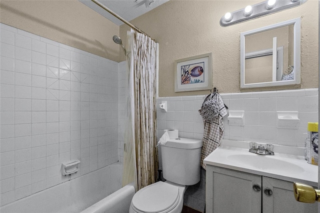 full bathroom with vanity, toilet, shower / bathtub combination with curtain, and tile walls