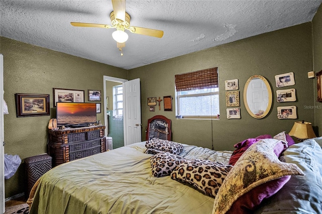 bedroom with ceiling fan and a textured ceiling