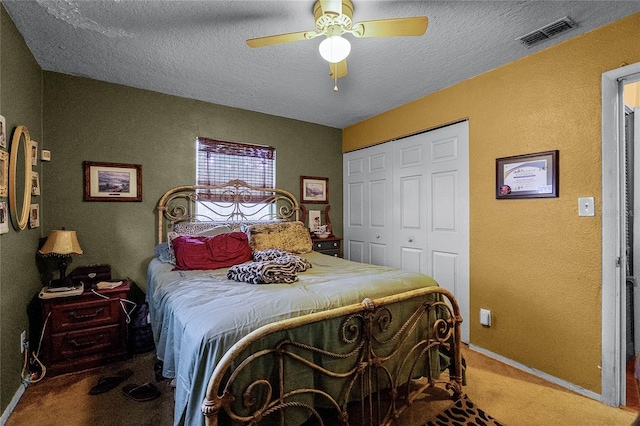 carpeted bedroom featuring ceiling fan, a textured ceiling, and a closet