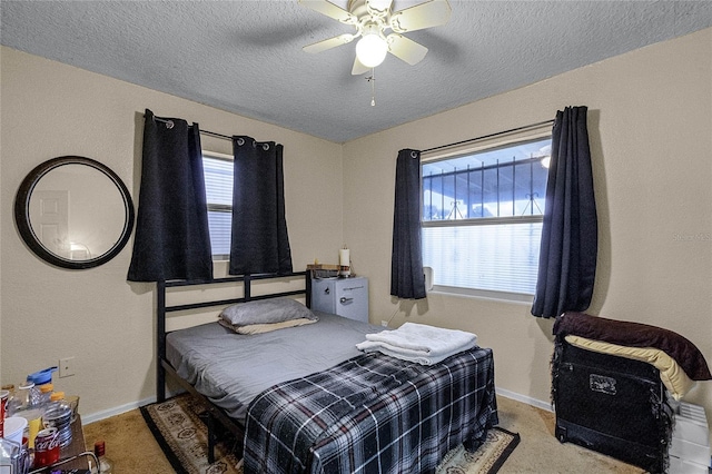 carpeted bedroom with a textured ceiling and ceiling fan