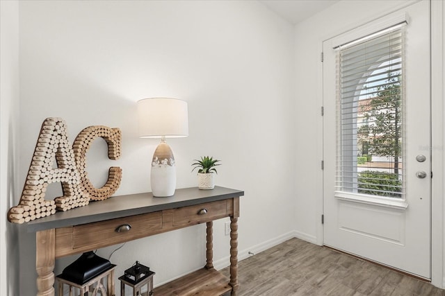 doorway to outside with wood finished floors and baseboards