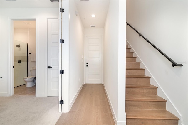 staircase with hardwood / wood-style flooring