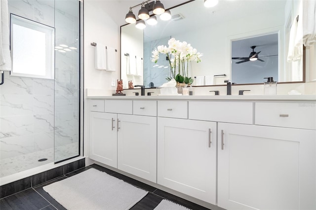 bathroom featuring a shower with shower door, vanity, tile patterned flooring, and ceiling fan