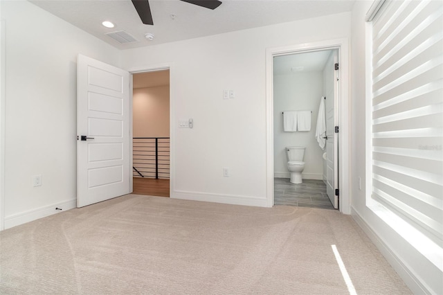 unfurnished bedroom with carpet floors, connected bathroom, and ceiling fan