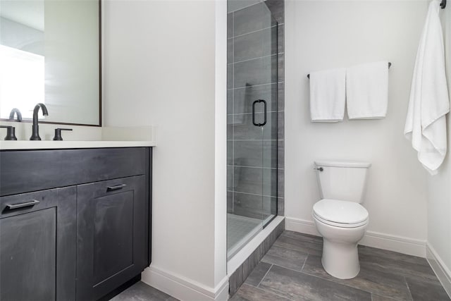 bathroom featuring toilet, an enclosed shower, and vanity