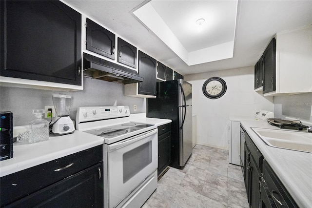 kitchen with white electric range, a raised ceiling, stainless steel refrigerator, and sink