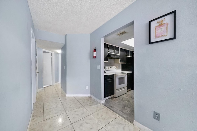 kitchen featuring light tile patterned floors, a textured ceiling, and white electric stove