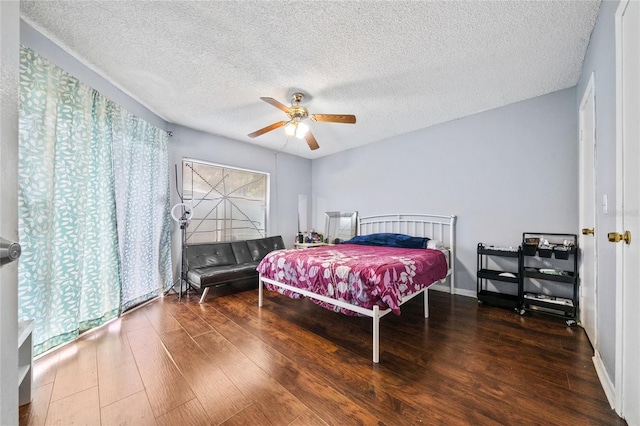 bedroom with a textured ceiling, dark hardwood / wood-style flooring, and ceiling fan