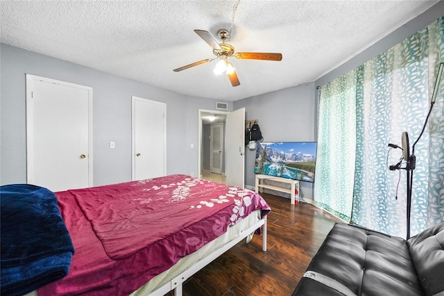 bedroom featuring ceiling fan, dark hardwood / wood-style flooring, and a textured ceiling