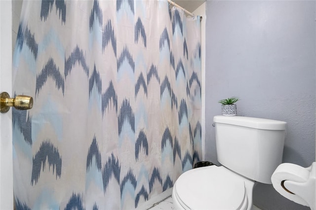 bathroom featuring curtained shower and toilet