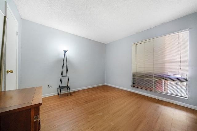 spare room featuring hardwood / wood-style floors and a textured ceiling