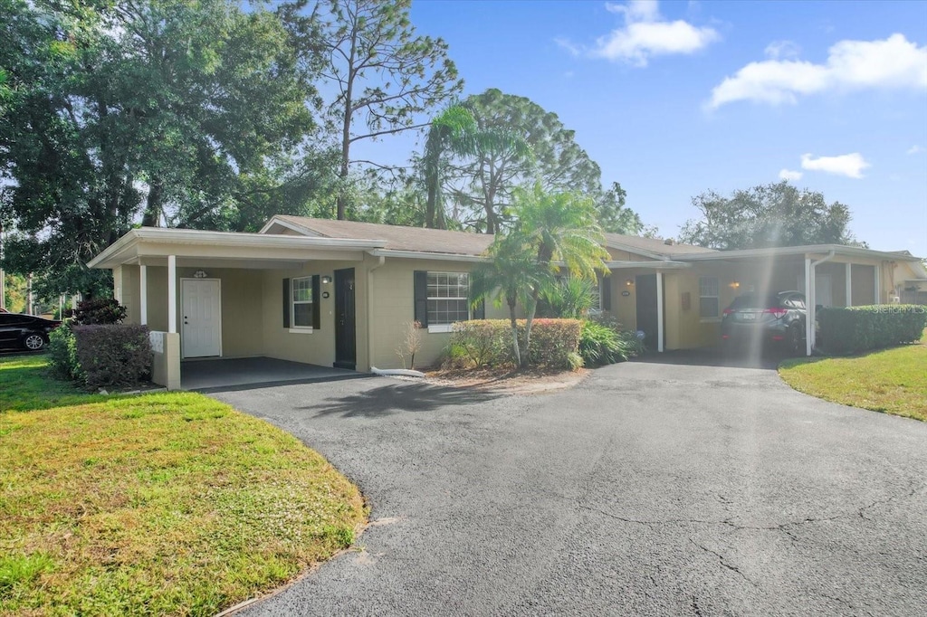 single story home with a front yard and a carport