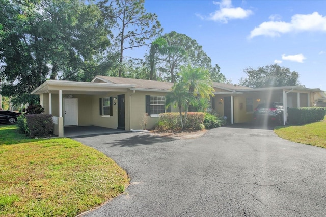 single story home with a front yard and a carport