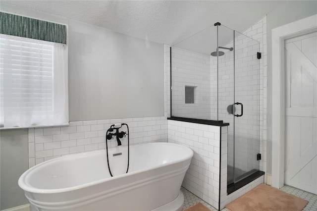 bathroom featuring tile patterned floors, plus walk in shower, and a textured ceiling