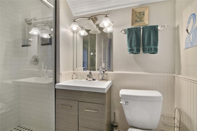 bathroom featuring a shower with door, vanity, and toilet