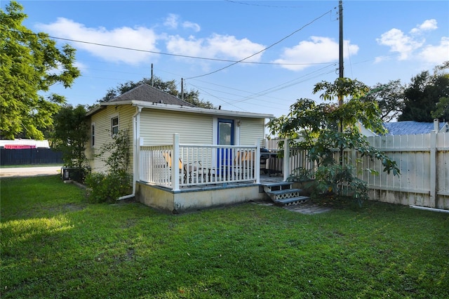 back of property with a yard and a deck