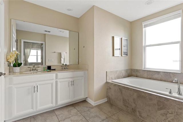 bathroom with tiled bath, tile patterned flooring, and vanity