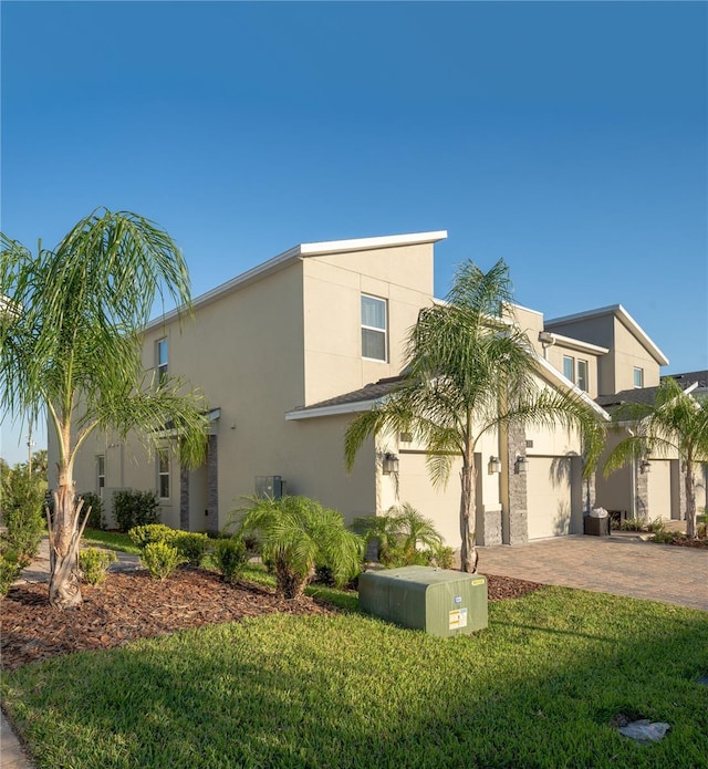 781 Ocean Course Ave Unit 601, Davenport, FL 33896 - view of front of home with stucco siding, decorative driveway, a front lawn, and a garage