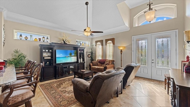 tiled living room with ceiling fan, ornamental molding, a textured ceiling, and french doors