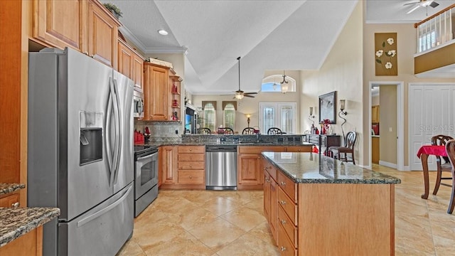 kitchen featuring high vaulted ceiling, appliances with stainless steel finishes, a textured ceiling, a kitchen island, and ornamental molding