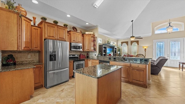 kitchen with ceiling fan, a center island, sink, stainless steel appliances, and kitchen peninsula