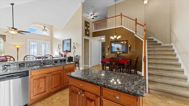 kitchen featuring stainless steel dishwasher, ceiling fan with notable chandelier, decorative light fixtures, and high vaulted ceiling