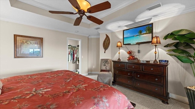 bedroom featuring crown molding, ceiling fan, a spacious closet, light colored carpet, and a closet