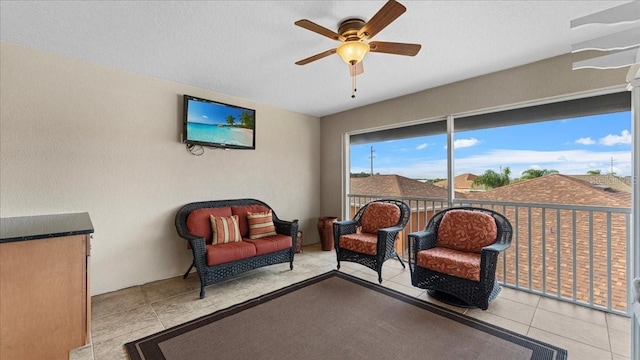 living area featuring ceiling fan and light tile patterned flooring