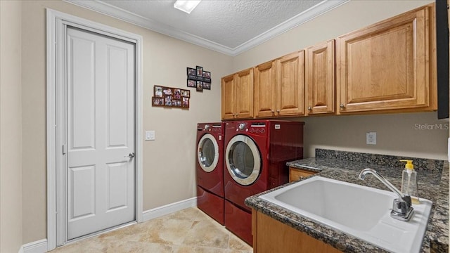 laundry room with cabinets, sink, crown molding, washer and dryer, and a textured ceiling