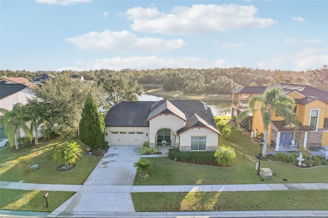 view of front of home with a garage, a water view, and a front yard