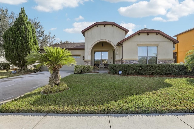 mediterranean / spanish-style home featuring a garage and a front lawn