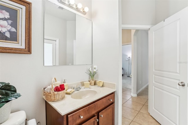 bathroom featuring tile patterned flooring, vanity, and toilet