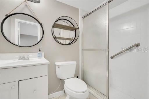 bathroom with vanity, toilet, and an enclosed shower