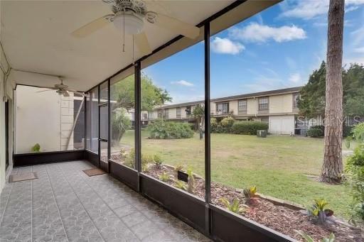 unfurnished sunroom featuring ceiling fan