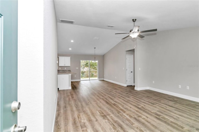 unfurnished living room with ceiling fan, vaulted ceiling, and light hardwood / wood-style flooring