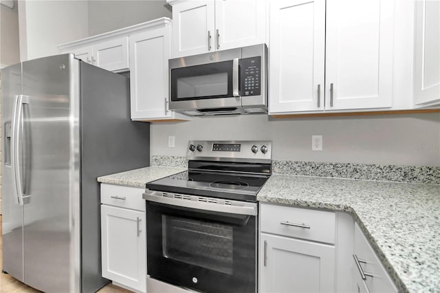 kitchen featuring light stone countertops, white cabinetry, and appliances with stainless steel finishes