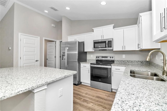 kitchen featuring light hardwood / wood-style floors, stainless steel appliances, light stone countertops, white cabinets, and sink