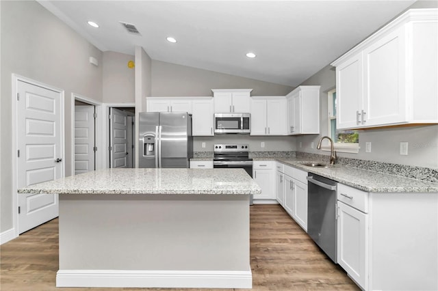 kitchen with white cabinets, sink, stainless steel appliances, and a center island