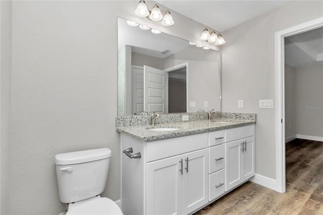 bathroom with hardwood / wood-style flooring, toilet, and vanity