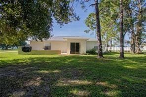 rear view of house featuring a yard