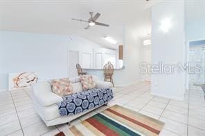 tiled living room with vaulted ceiling and ceiling fan