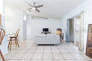 tiled living room featuring ceiling fan and lofted ceiling