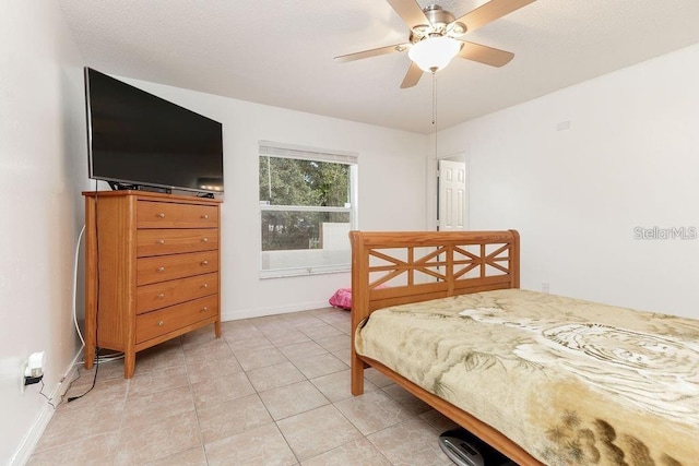 tiled bedroom featuring ceiling fan