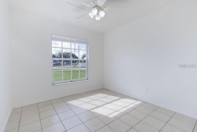 tiled empty room featuring ceiling fan