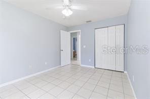 unfurnished bedroom featuring ceiling fan and a closet