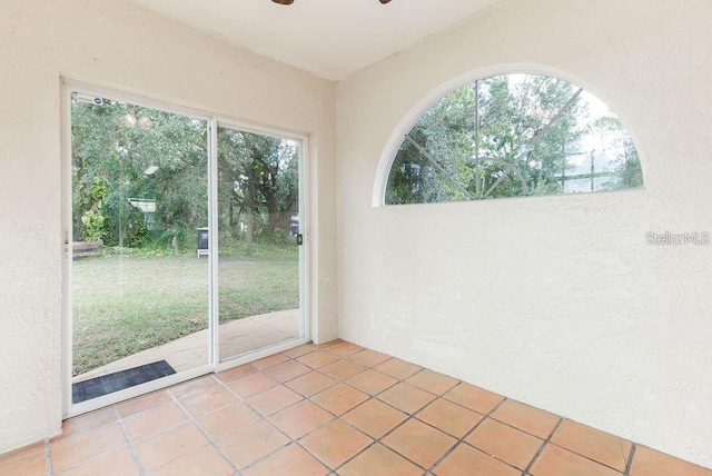 empty room featuring plenty of natural light and tile patterned flooring